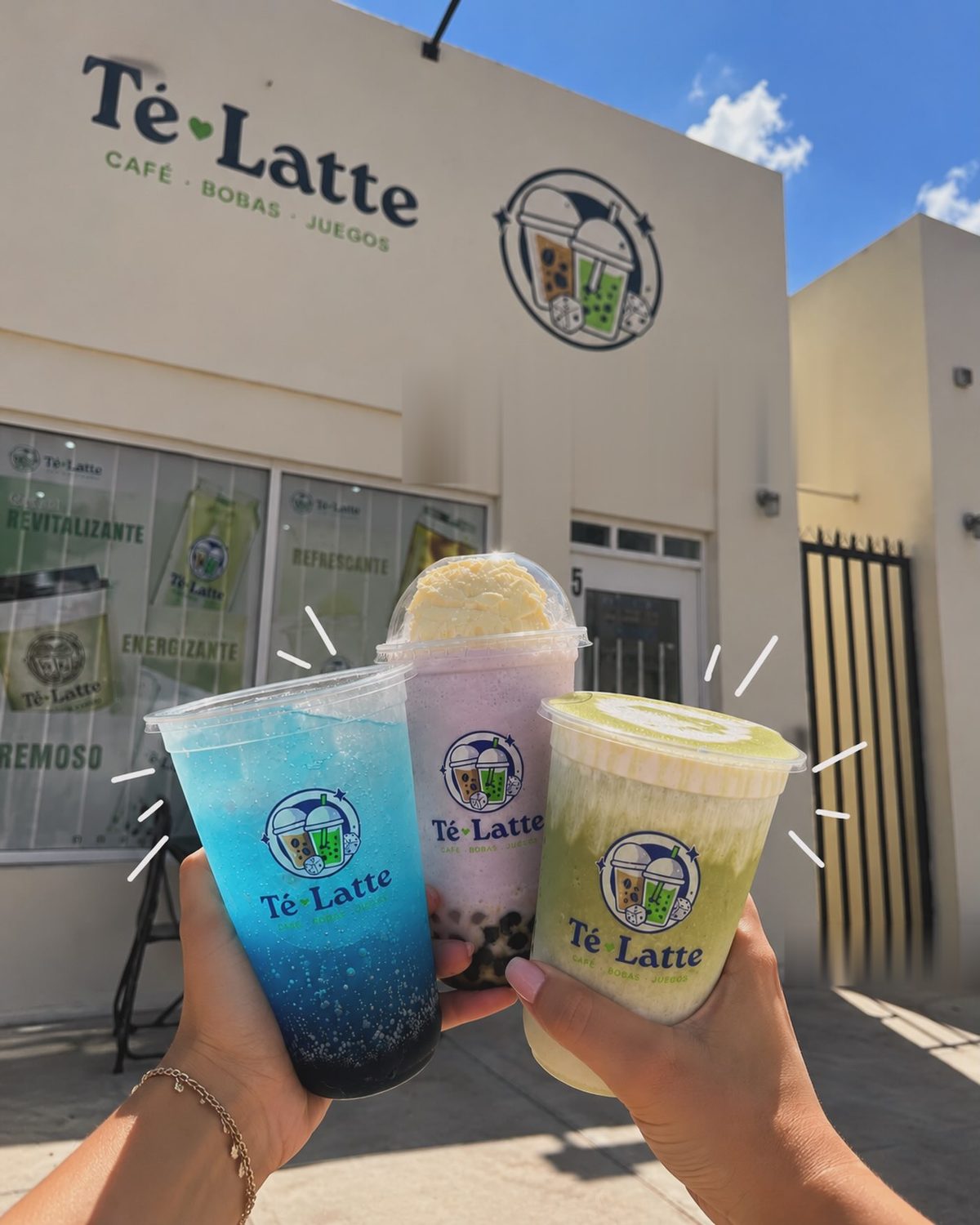 Tres bebidas de colores de Té-Latte frente a la fachada de la cafetería en Plaza Guadalupe